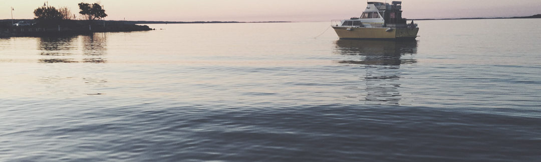 Fishing boat in the harbour on the still water at dusk, highlighting businesses that need a GST Account