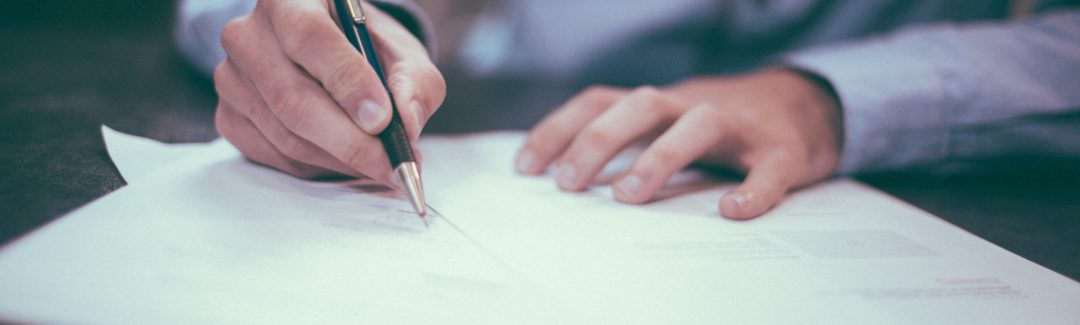 Man with pen writing on paper documents; highlighting proposed tax changes