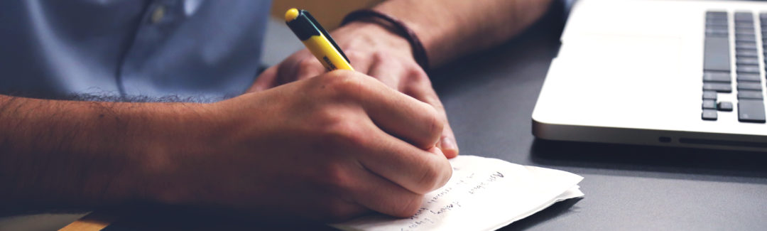 man with pen and paper writing; highlighting tax breaks for small businesses